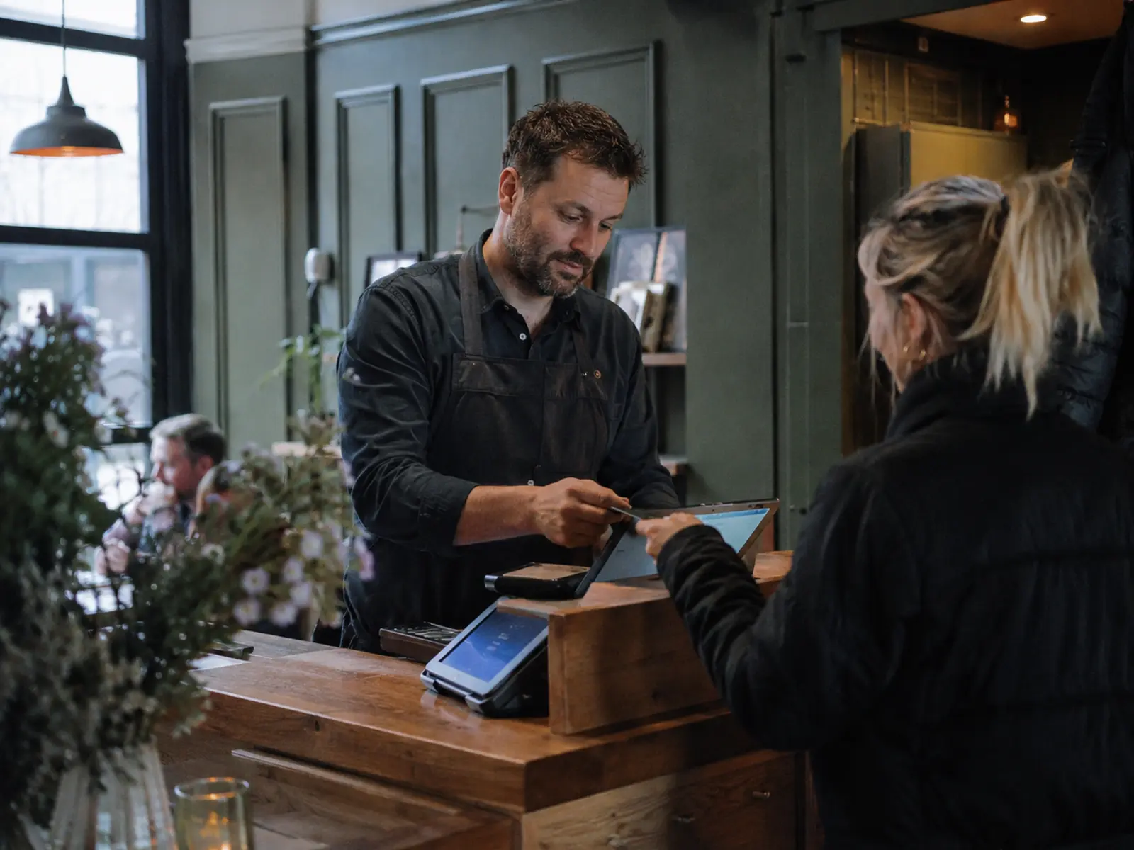 Business owner taking an online booking and deposit at the counter