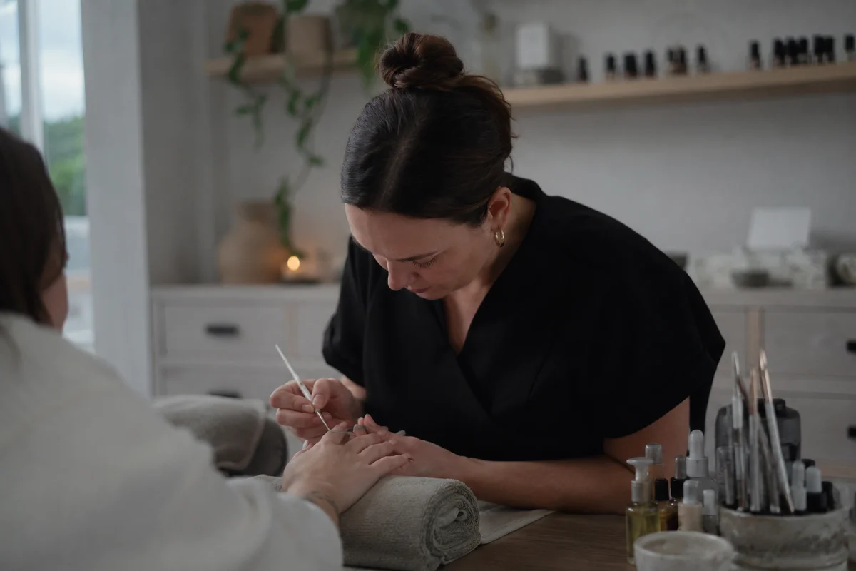 A beauty therapist concentrating on a treatment